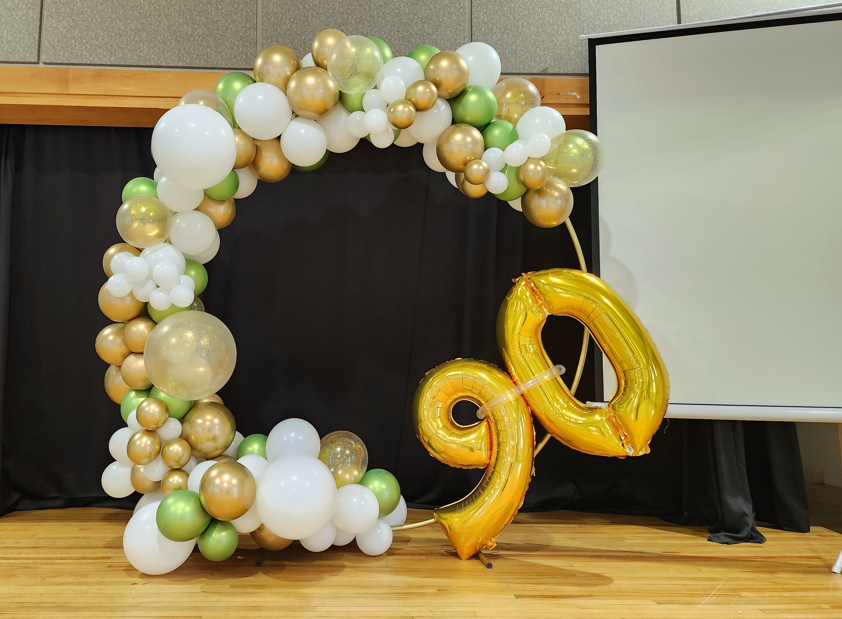 Gold, white and green balloon arch for 90th birthday