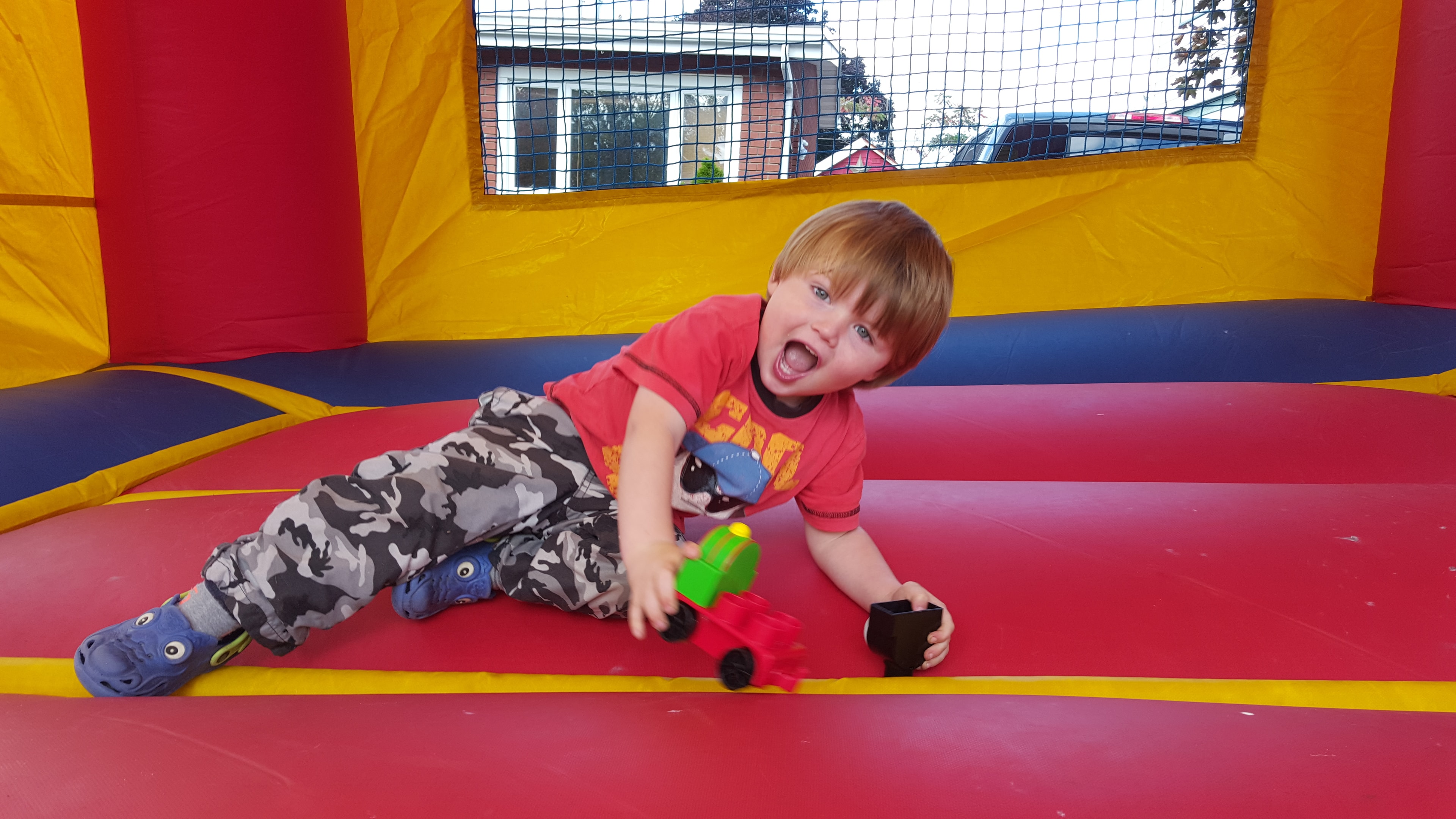 Child playing inside a red and yellow bounce castle