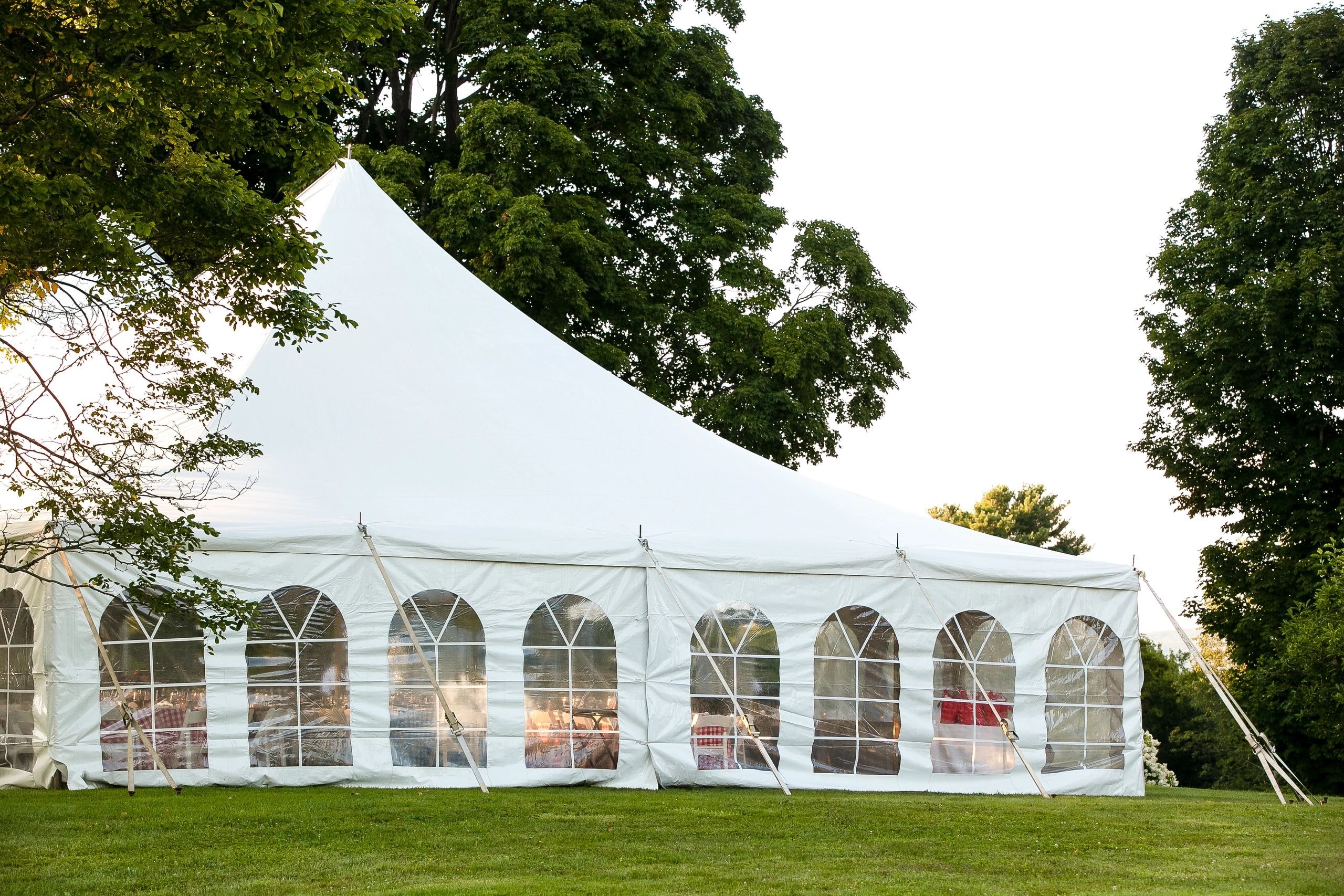 White event tent with arched windows at outdoor party